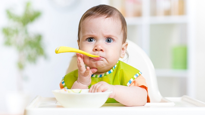 funny baby eating food on kitchen